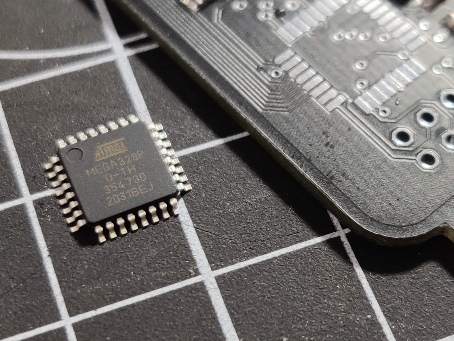 ATmega328P-AU component beside the unassembled PCB